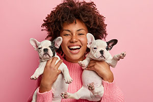 woman holding french bulldogs community